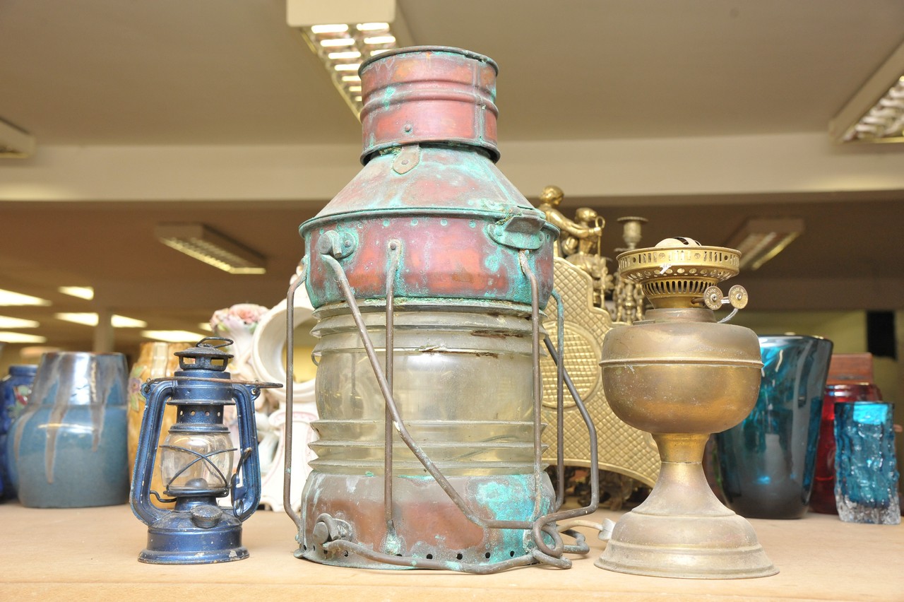 A large ship's lantern and two oil lamps