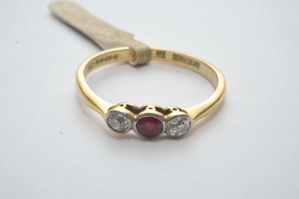 A ladies 18ct gold ring set with a central ruby flanked by diamonds