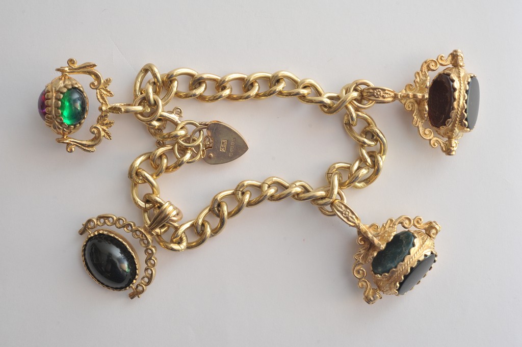 A 9ct gold bracelet with four attached stone set swivel fobs