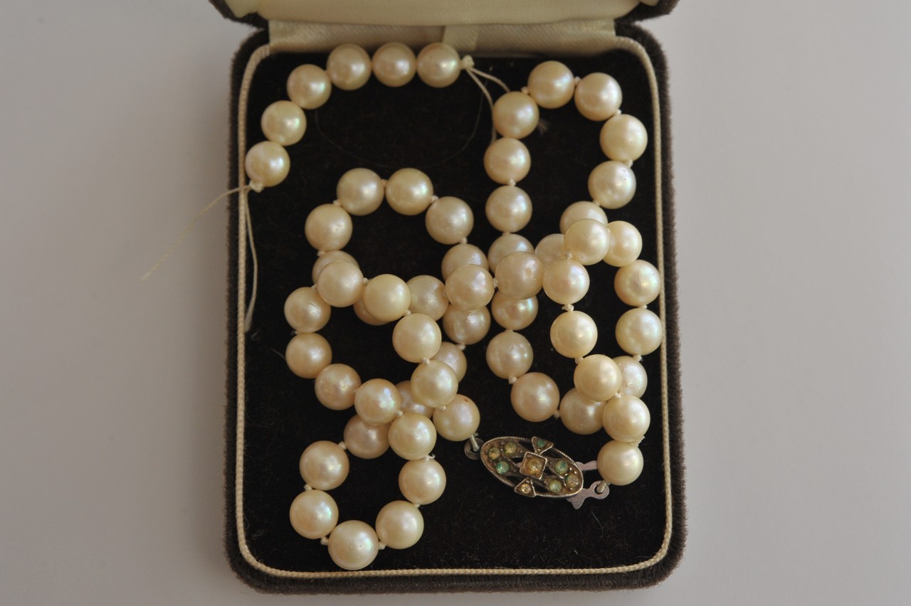 A vintage single strand cultured pearl necklace with stone set silver clasp