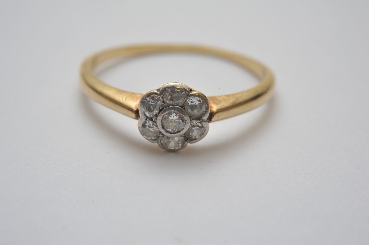 A ladies 18ct yellow gold ring set with seven diamonds in a flower shaped cluster