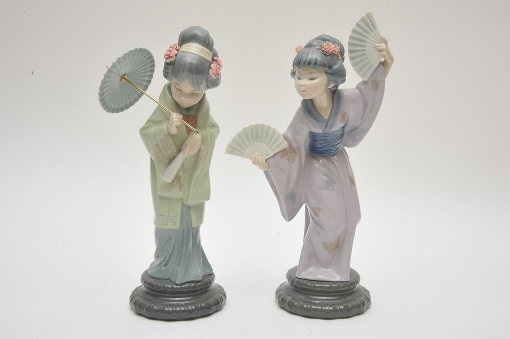 Two Lladro figures depicting Chinese ladies in traditional dress holding a fan and parasol