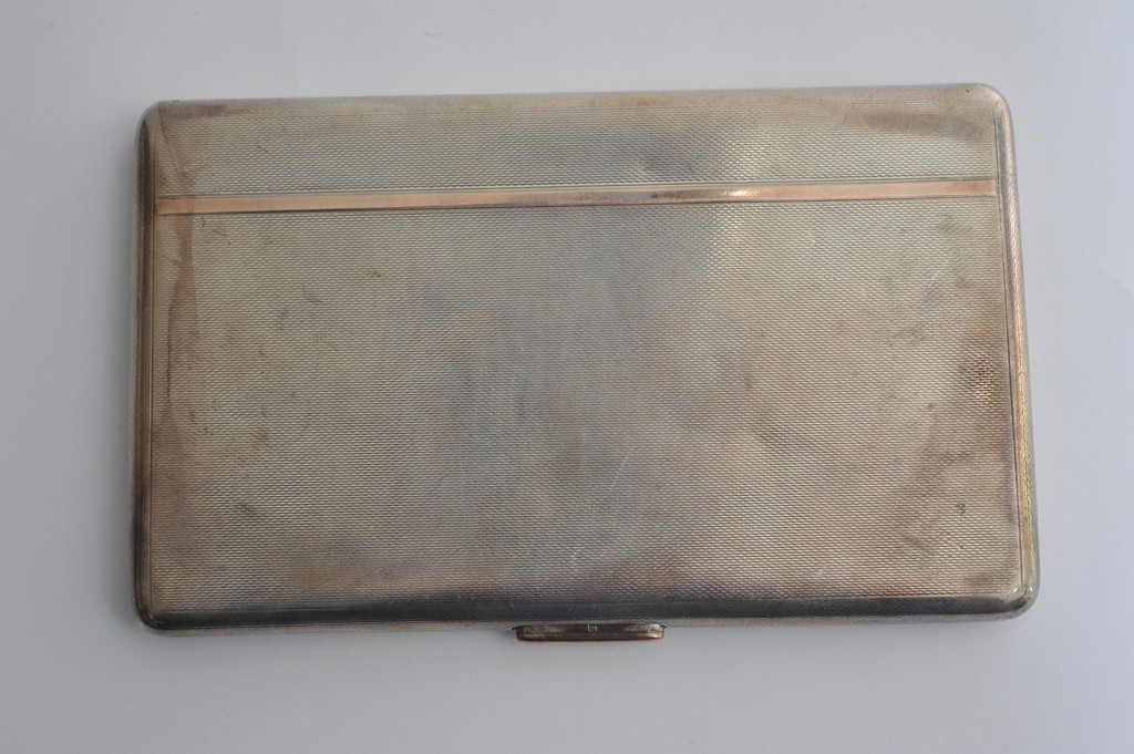 A silver cigarette case of rectangular shape
