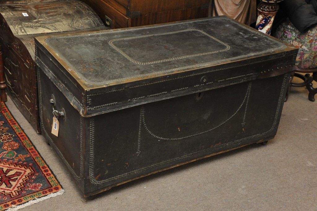 A very large studded leather storage trunk with key