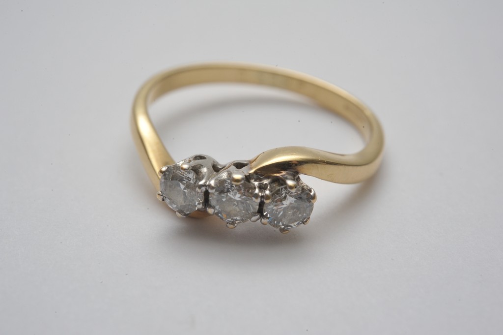 A ladies 18ct yellow gold diamond trilogy ring with crossover shank