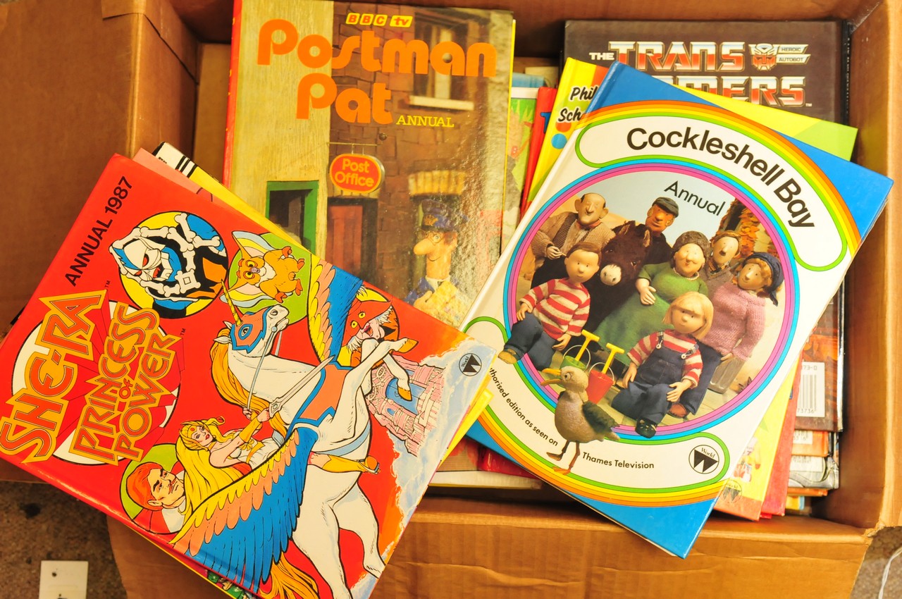 A box of 1980's children's annuals including Transformers