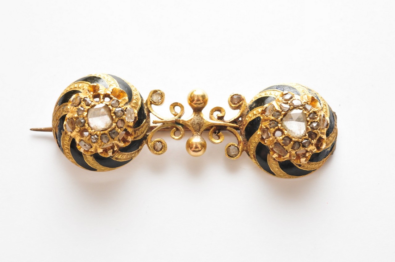 A 19th century gold and black enamel brooch set with numerous mine and old cut diamonds