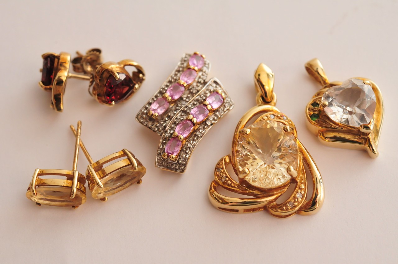 A collection of three ladies gold pendants and two pair of earrings of varying design and set with