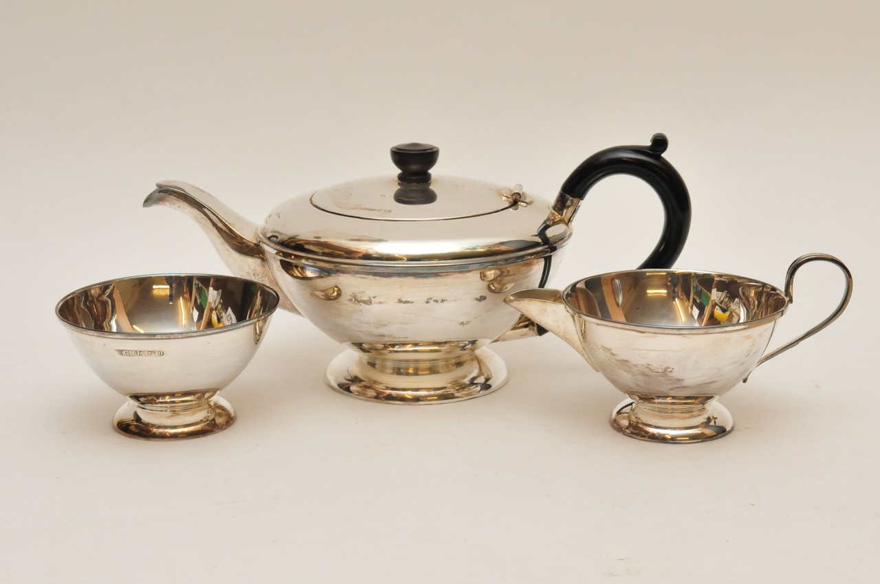 A silver tea set comprising tea pot, sugar bowl, and milk jug 700g approx, she field 1937 hallmarks