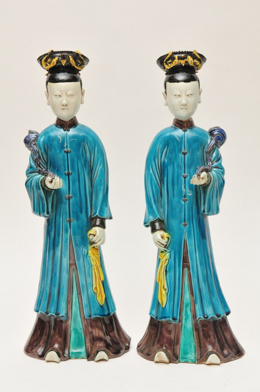 A pair of large Chinese fahua type figures in turquoise glazed robes holding Ruyi in a raised arm