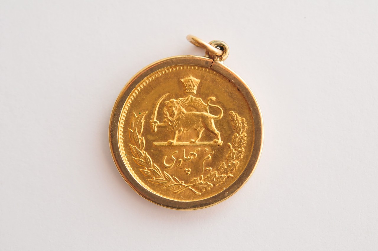 An Iranian 1/2 Pahlavi gold coin with profile of Mohammad Reza Pahlev in a pendant bezel mount