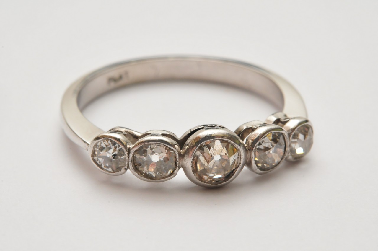 A ladies platinum ring set with five graduating old cut diamonds