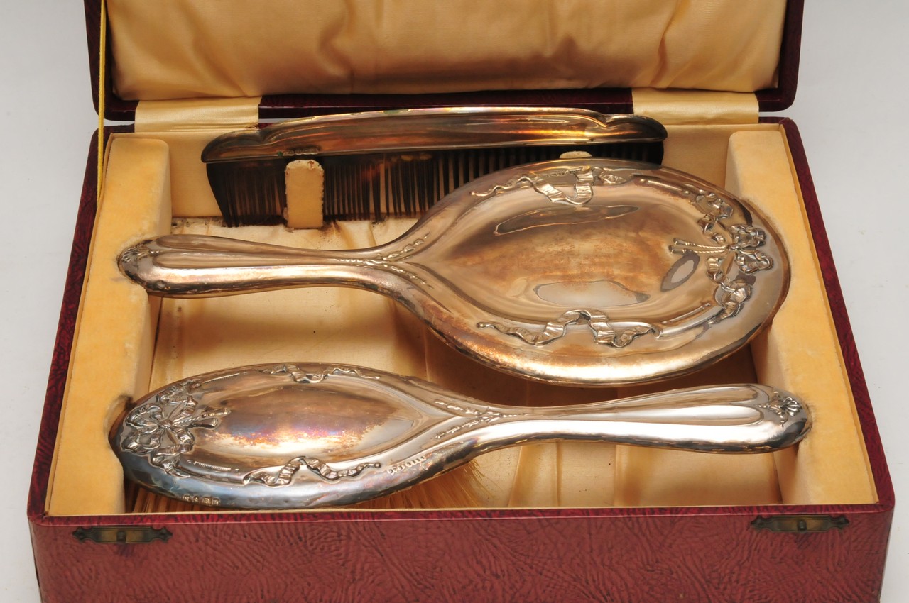 A cased silver dressing table set comprising a mirror brush and comb