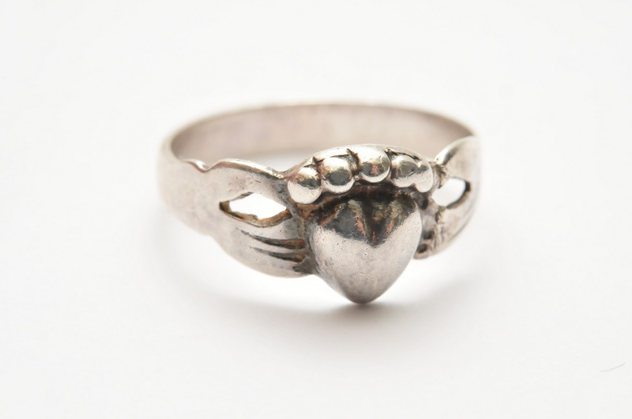 An antique silver Fede Friendship ring in the form of two hands clasping a heart