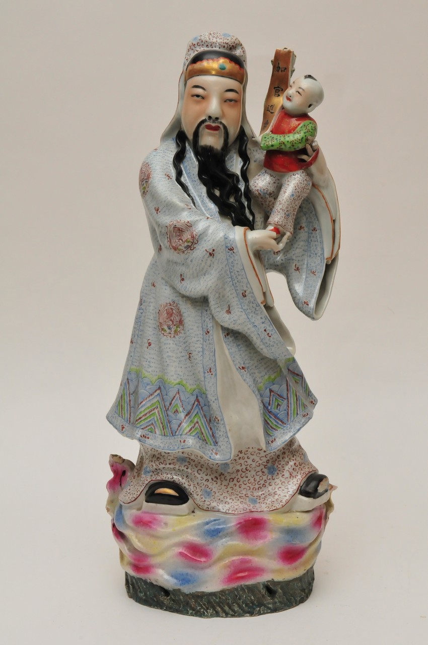 A large polychrome Chinese figure of a robed bearded man holding high a child with a scroll. Height:
