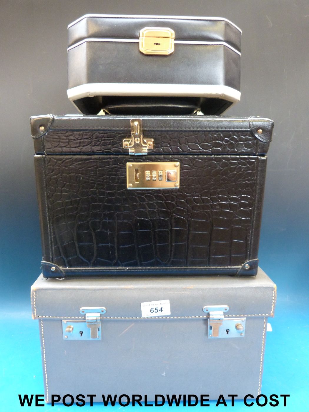 A multi layered carrying jewellery/vanity case, leather attaché case and a similar brushed metal