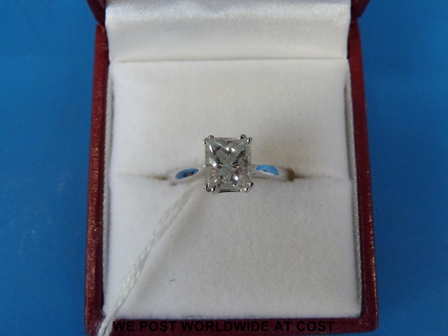 A white metal ring set with an emerald cut diamond of approx 1.7ct, marked 18ct