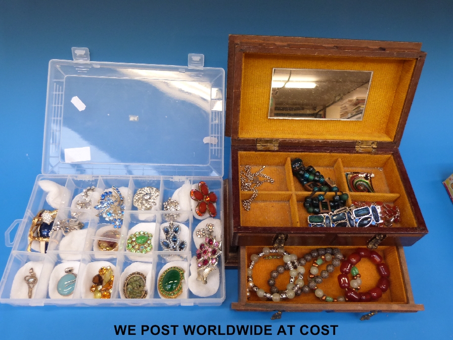 A wooden jewellery box with various costume jewellery together with a quantity of brooches and two