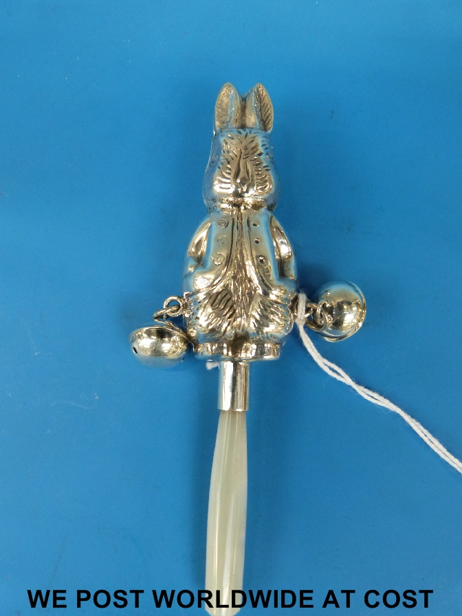 A white metal baby's rattle modelled as a rabbit with two bells attached marked 925