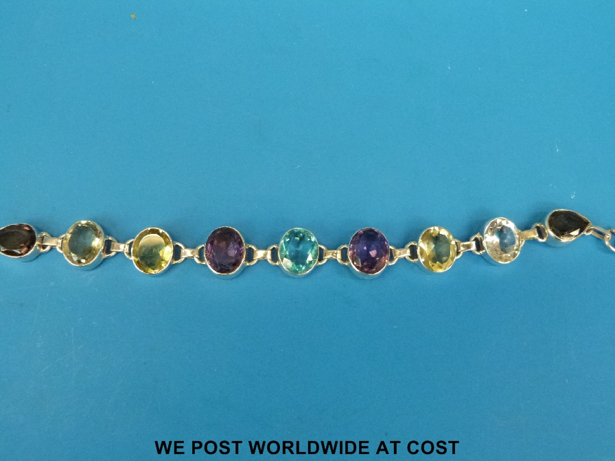 A white metal and gem set bracelet with amerthyst, topaz, smokey quartz etc