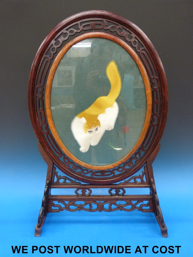 A Japanese silk screen with cat and grasshopper, in fretwood frame, height 74cm