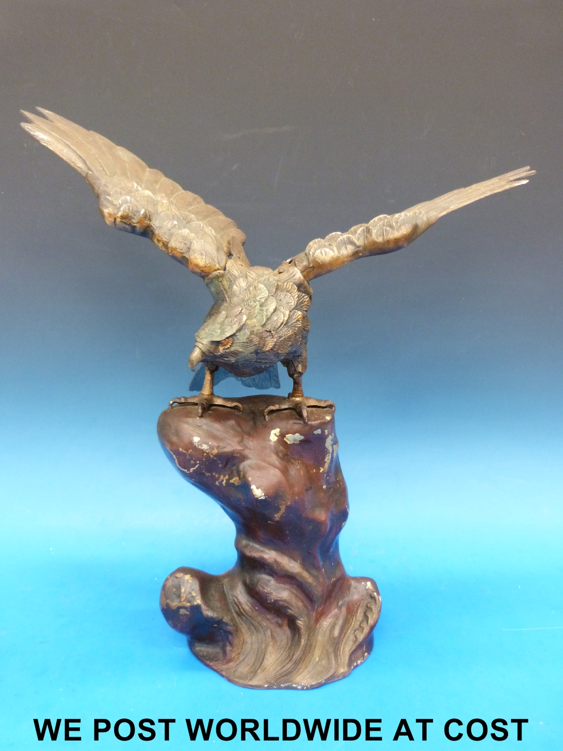 A naturalistic cast metal model of an eagle on a rocky outcrop with Oriental style character mark to - Image 2 of 3