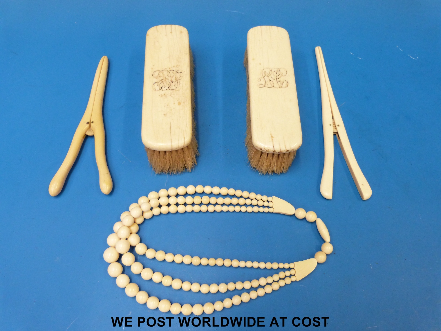 An ivory bead necklace together with a pair of ivory-backed brushes and two pairs of ivory glove