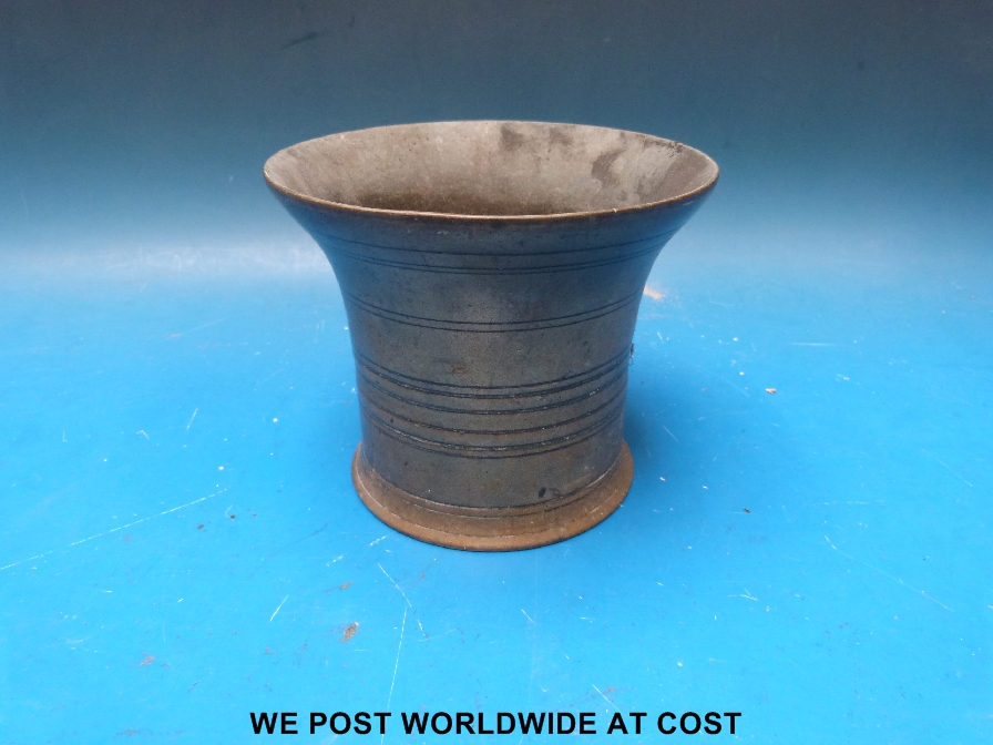 A bronze pestle with ribbed sides.