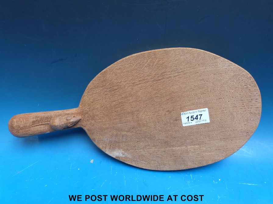 An oak cheeseboard, with carved mouse to handle, length 37 cm.