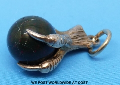 A 9ct gold charm in the form of an eagle's claw holding an agate ball (B'ham), 2.7 g all in.