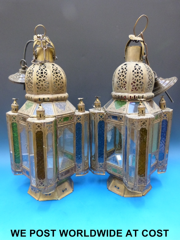 A pair of Indian pierced brass and coloured glass hanging lamps.