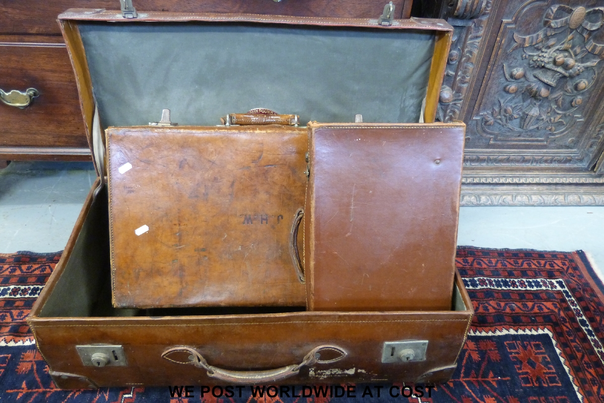 Three vintage leather suitcases, one with British Railways and Southern Railways luggage labels
