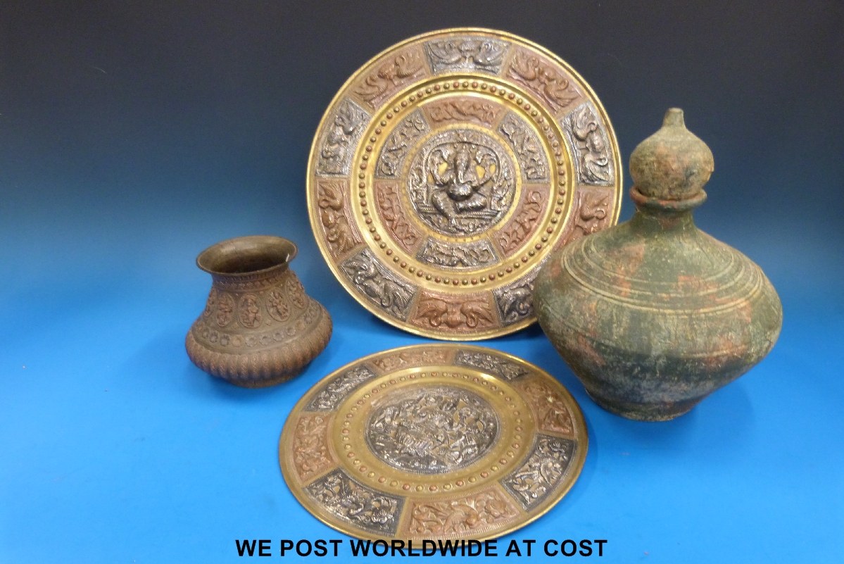 An Indian repousse decorated vase together with a similar plate and an eastern earthenware vase