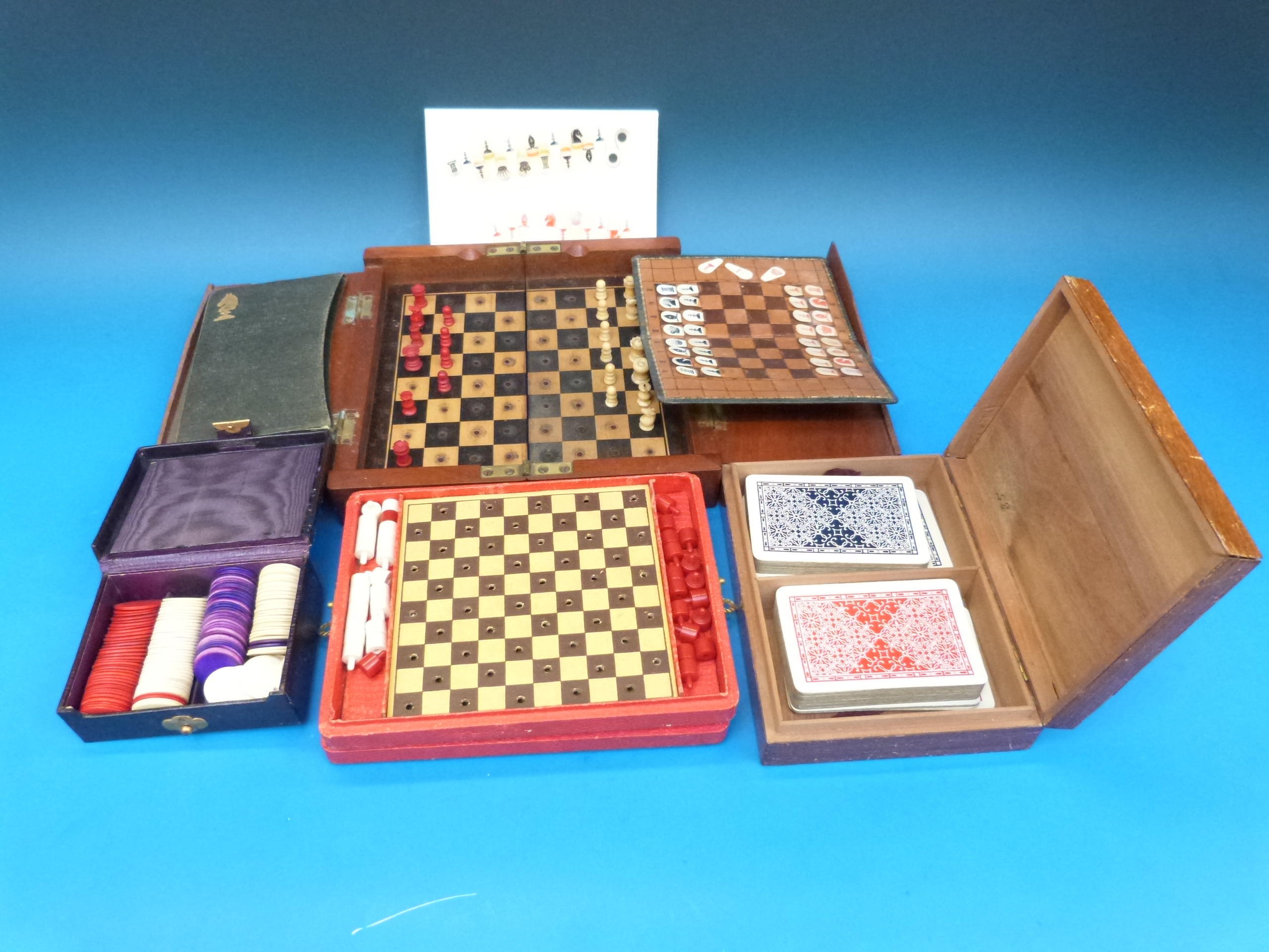 A travel chess set in embossed case with extra pieces, together with a mahogany-cased folding travel