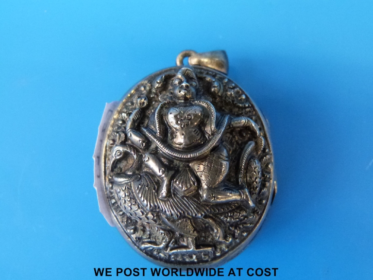 An Indian white metal pendant with relief moulded deities
