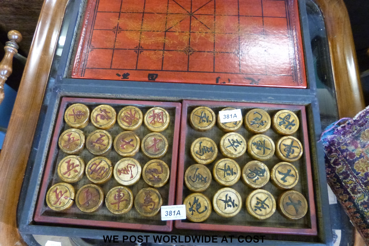 A Chinese chess set in lacquer case.