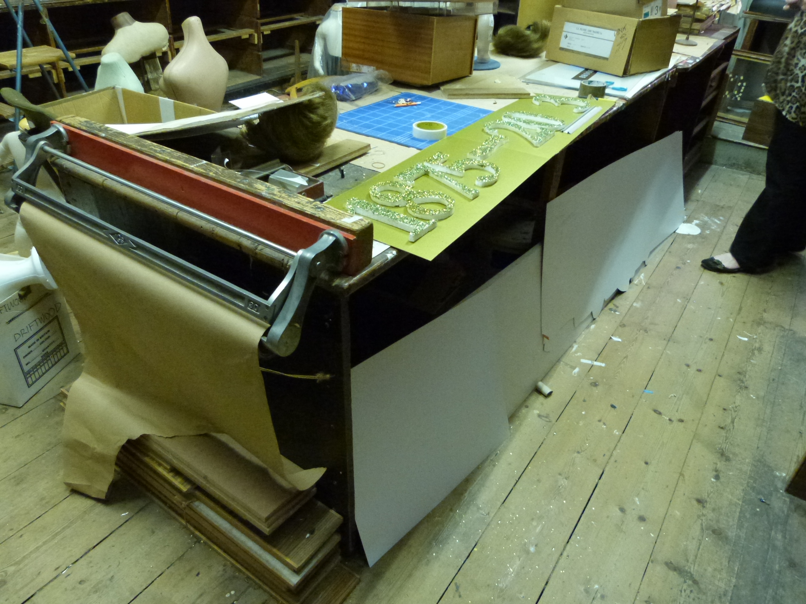 An oak faced shop display shelf unit together with a particularly large workbench, fitted drawer