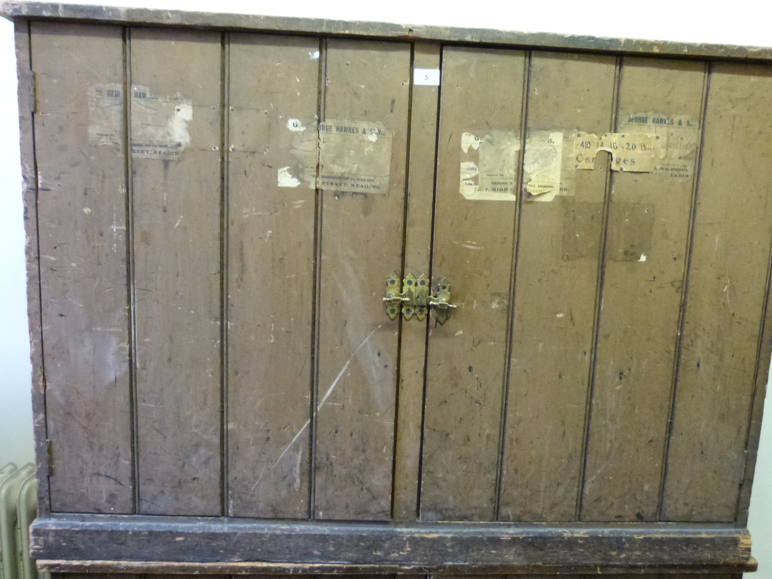 A painted pine cupboard with brass handles, having labels to front for George Hawkins,