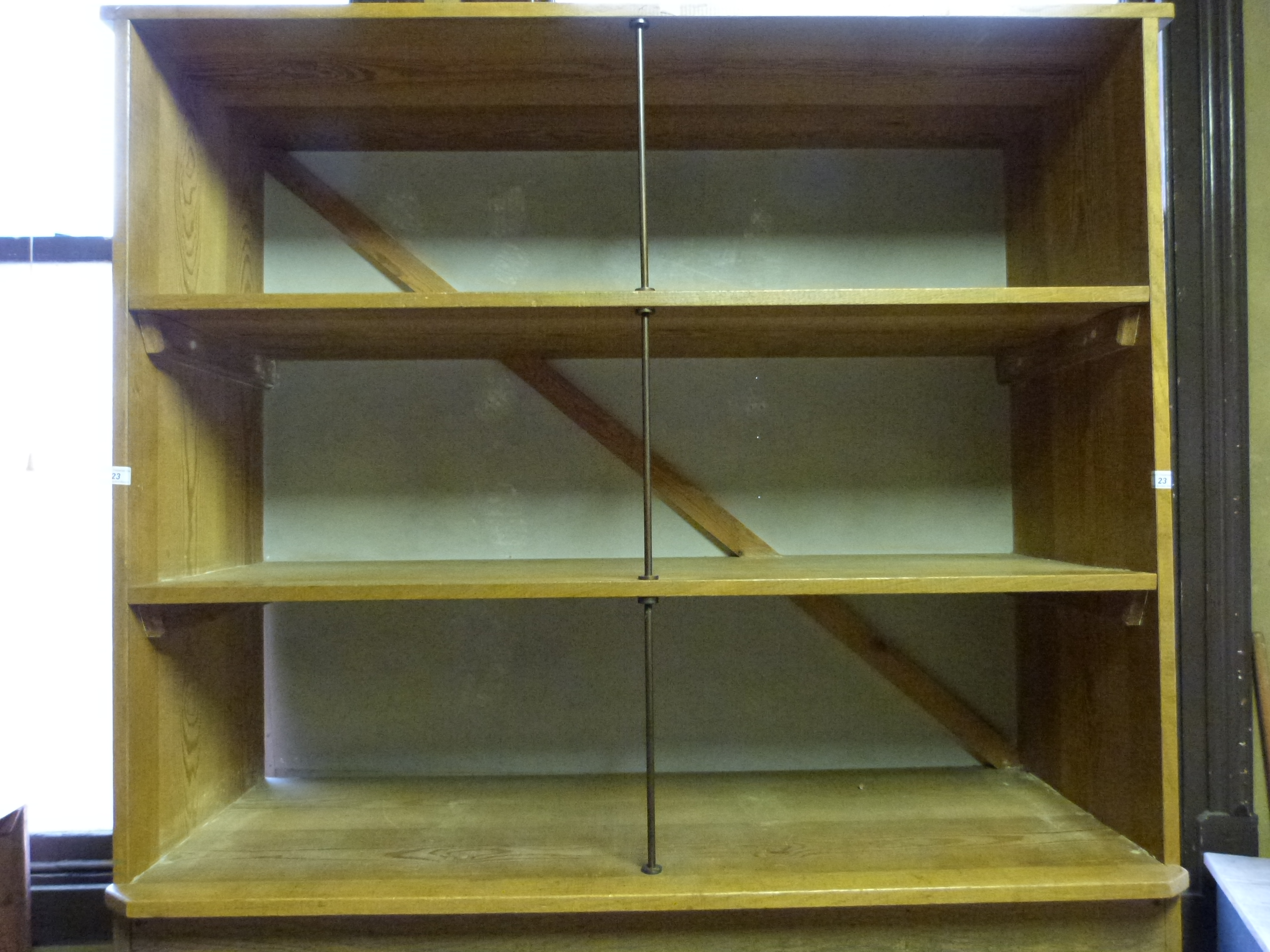 An oak and pine shop fitting display unit, having three shelves with supporting bronze columns to