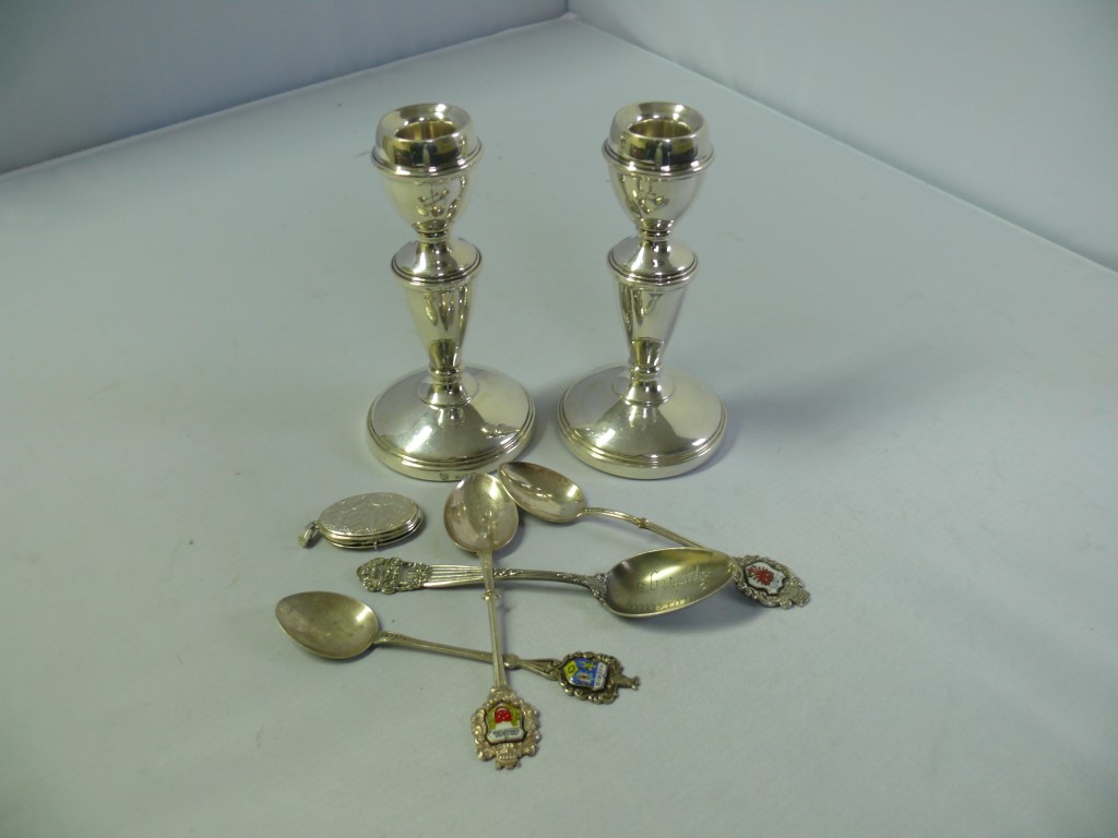 A pair of silver candlesticks; together with a sterling teaspoon 'Colorado Springs'; three .800