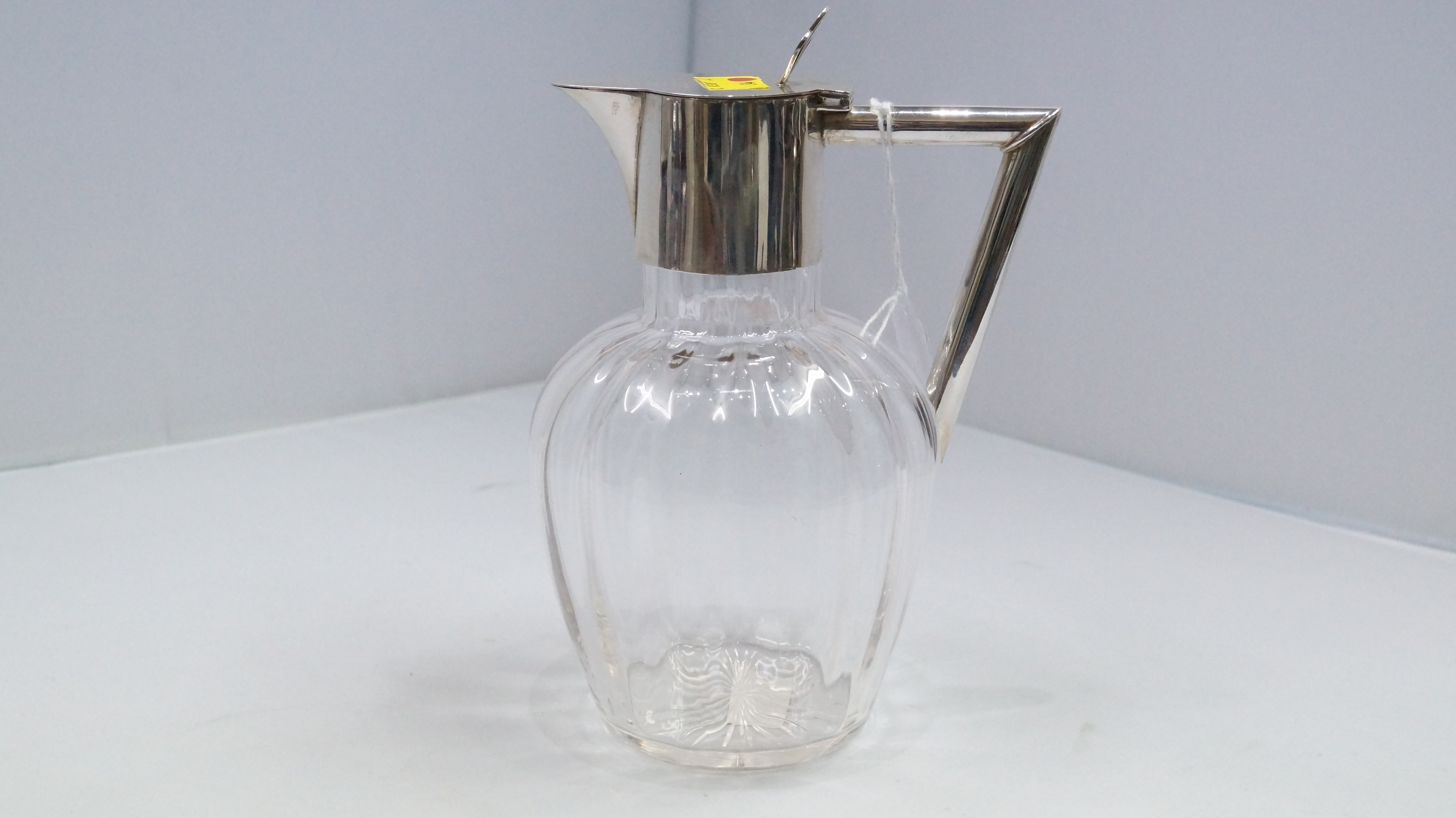 An Edwardian glass and silver mounted claret jug, by W ?, Birmingham 1909, 19.5cm.   Condition