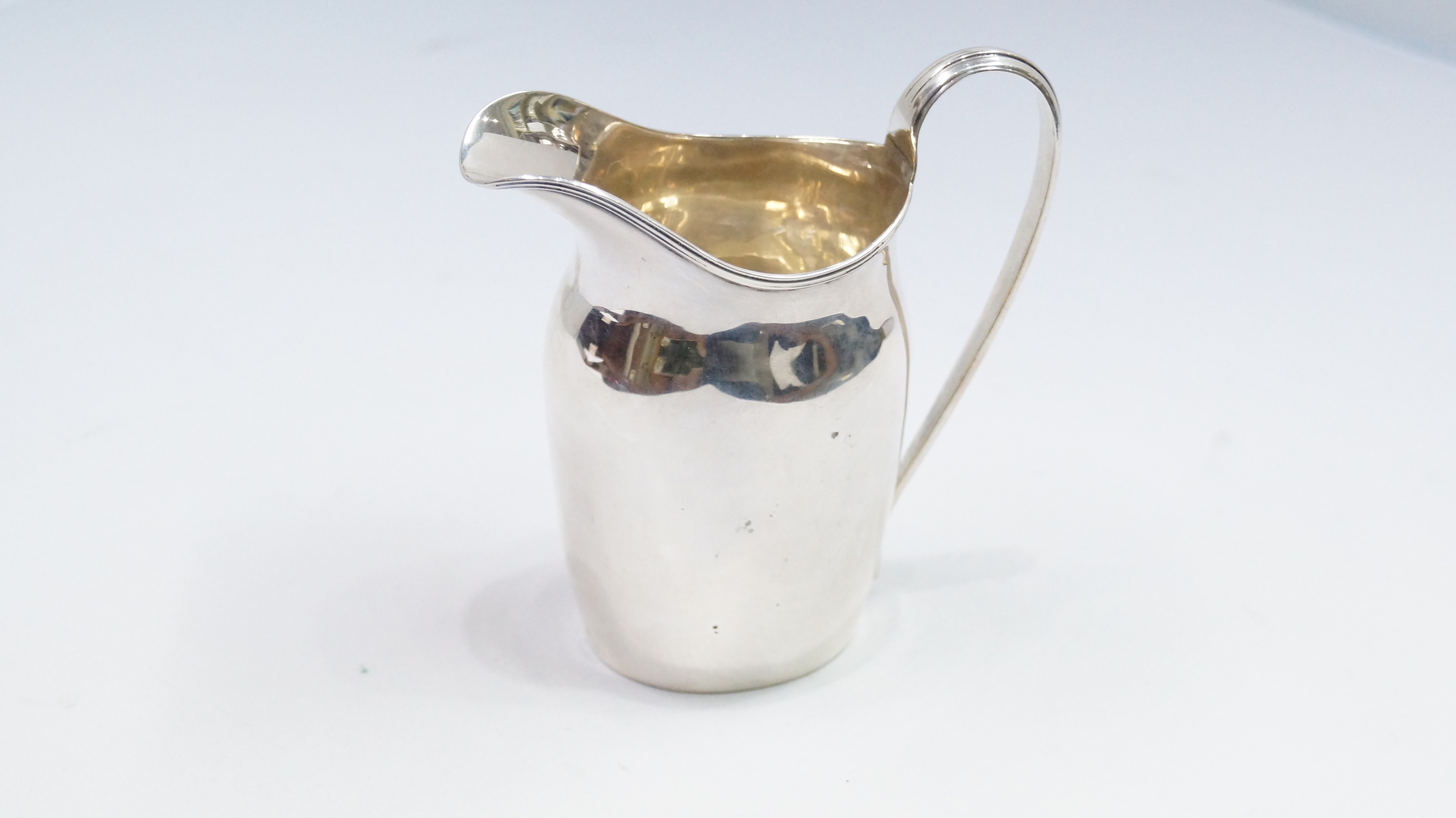 A Georgian style silver milk jug, by George Nathan & Ridley Hayes, Chester 1912, 11cm, 114g.