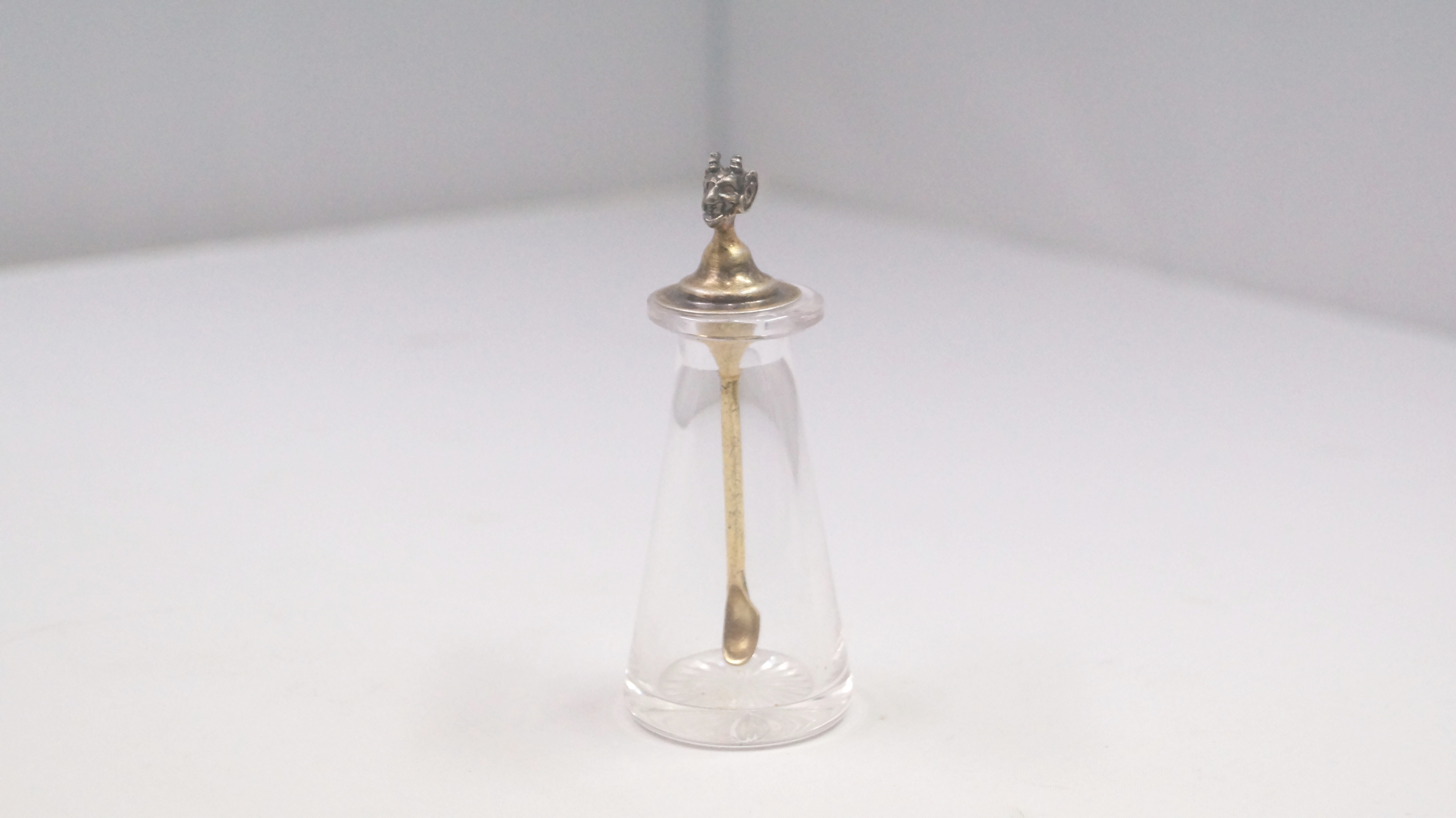 A clear glass snuff bottle, by Hukin & Heath, Birmingham 1936, the silver gilt stopper having