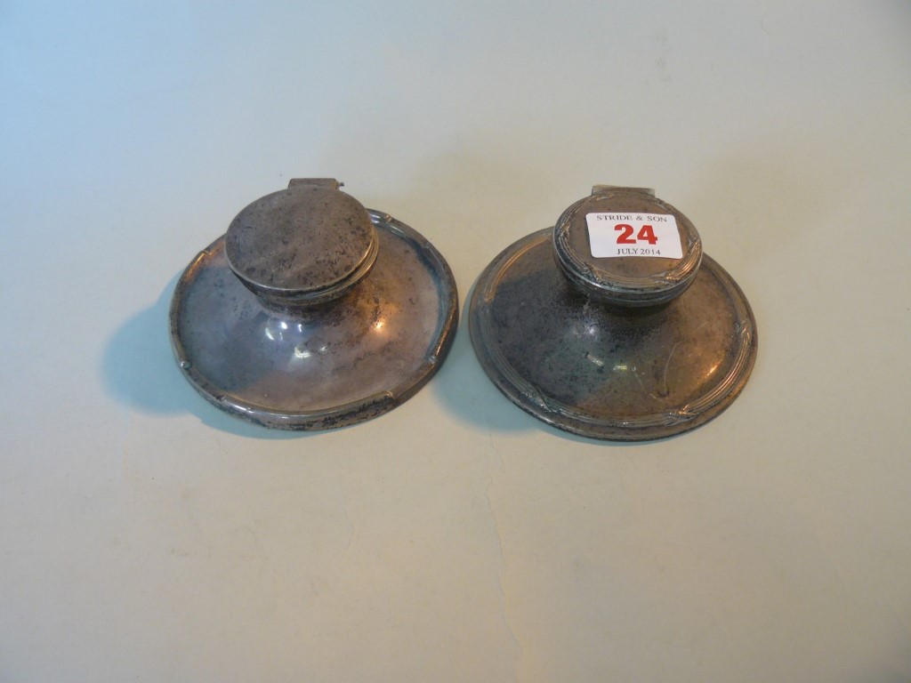 Two silver capstan inkwells, weighted.