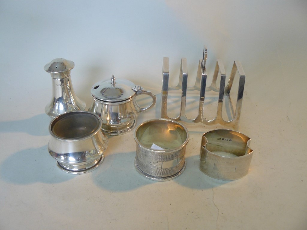 A silver three piece cruet set, by J G Ltd, Birmingham 1943; together with a silver toast rack;