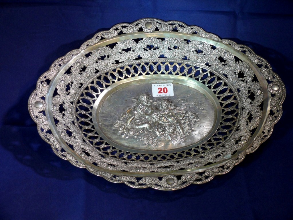 A continental white metal oval basket, stamped 800, decorated cherubs to centre and pierced floral