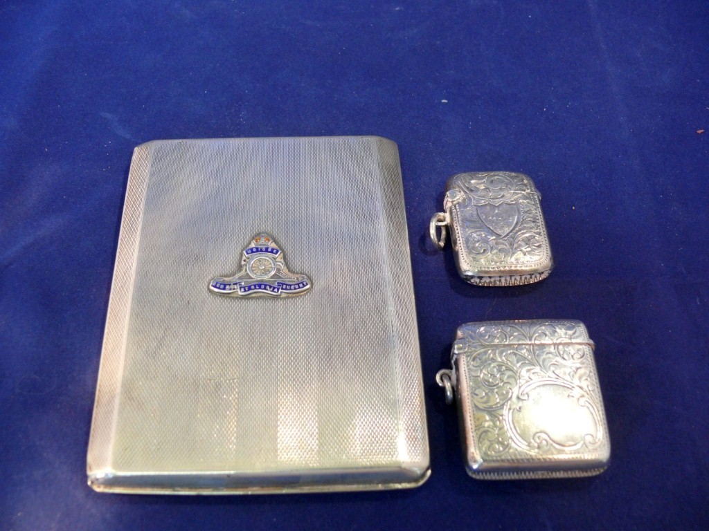 A silver cigarette case, having Royal Artillery crest; together with two silver vesta cases, 200g.