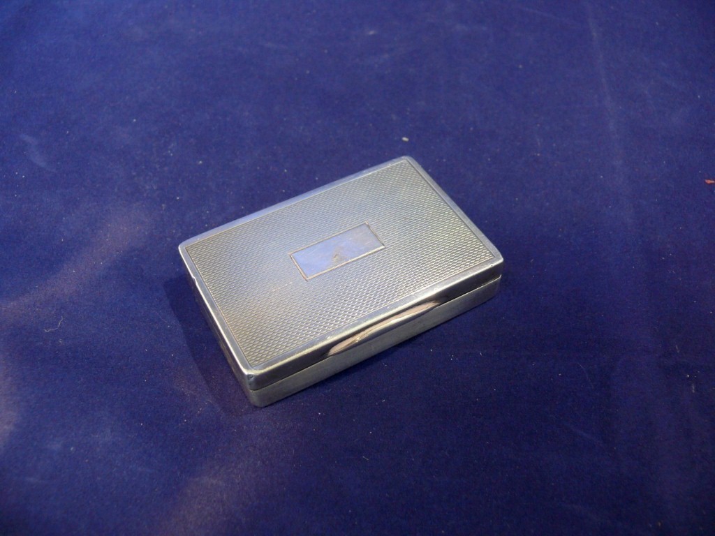 A silver snuff box, by JEG, Birmingham 1937, having engine turned lid, 64g, 6.5 x 4.4cm.