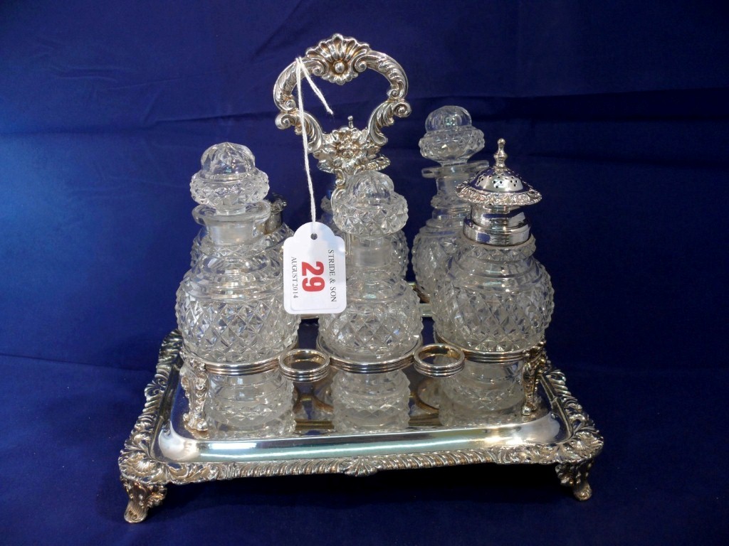 A silver plated cruet stand, with six unmatched glass bottles.