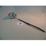 A George IV silver punch ladle, marks rubbed, inset coin to bowl, with twisted whalebone handle,